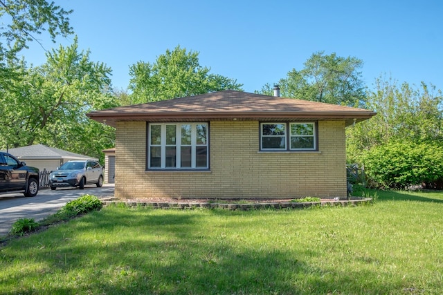 34 E 159th St, South Holland, IL 60473 - view of side of home with brick siding, a yard, and a garage