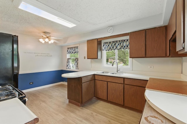2236 Thornton Lansing Rd, Lansing, IL 60438 - kitchen featuring a sink, a textured ceiling, black appliances, a peninsula, and light countertops