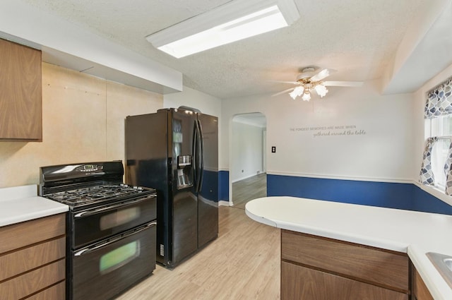 2236 Thornton Lansing Rd, Lansing, IL 60438 - kitchen with black appliances, a textured ceiling, light wood-type flooring, ceiling fan, and arched walkways