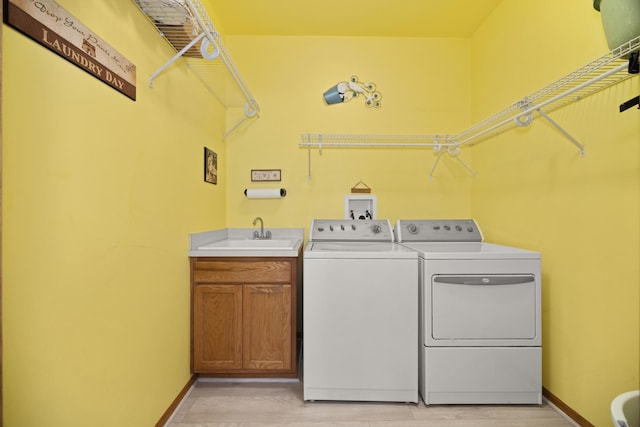 595 Sudbury Cir, Oswego, IL 60543 - washroom with washing machine and clothes dryer, cabinet space, baseboards, and light wood finished floors
