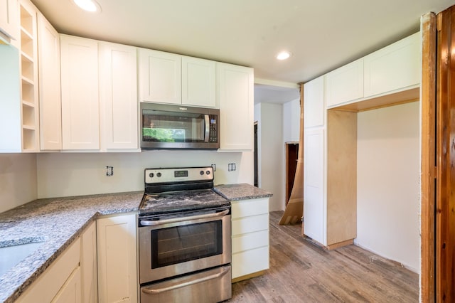 4 E Lincoln St, Mount Morris, IL 61054 - kitchen with stainless steel appliances, light wood-style floors, recessed lighting, white cabinets, and light stone counters