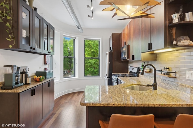 1956 W Bradley Pl Unit 2W, Chicago, IL 60613 - kitchen with appliances with stainless steel finishes, open shelves, dark wood-type flooring, light stone countertops, and backsplash