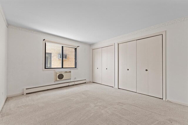 2155 N Harlem Ave Unit 205, Chicago, IL 60707 - unfurnished bedroom with baseboard heating, multiple closets, carpet floors, and a wall mounted air conditioner