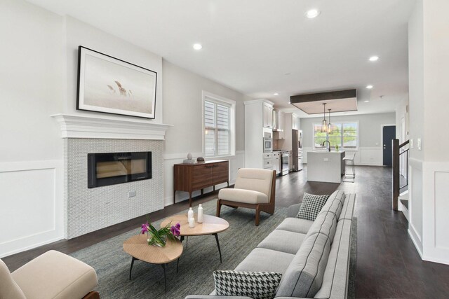 4637 S Michigan Ave, Chicago, IL 60653 - living room featuring dark wood-type flooring, a wainscoted wall, a tile fireplace, recessed lighting, and a decorative wall