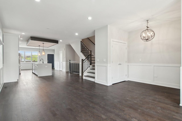 4637 S Michigan Ave, Chicago, IL 60653 - unfurnished living room with a chandelier, a sink, stairs, dark wood-style floors, and a wainscoted wall