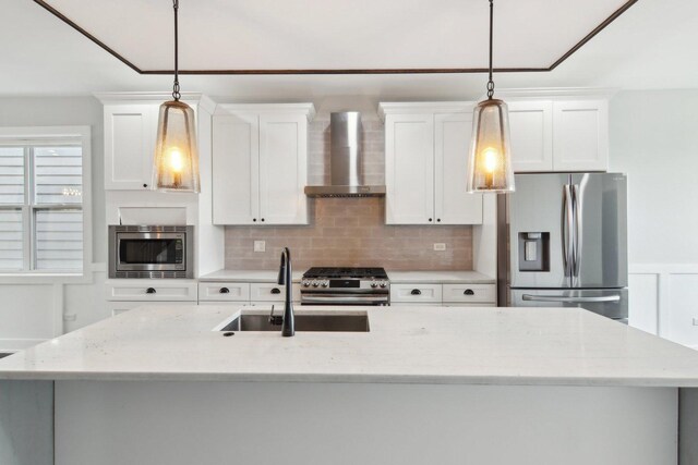 4637 S Michigan Ave, Chicago, IL 60653 - kitchen featuring wall chimney range hood, stainless steel appliances, an island with sink, a sink, and white cabinets