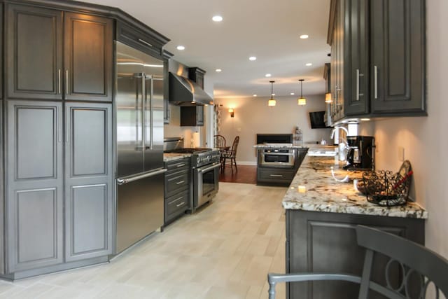 6421 157th St W, Oak Forest, IL 60452 - kitchen featuring high end appliances, wall chimney exhaust hood, recessed lighting, decorative light fixtures, and light stone countertops