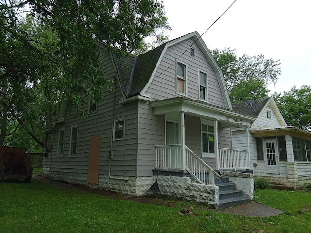 2324 W Wiswall St, Peoria, IL 61605 - colonial inspired home with a gambrel roof, a porch, a front lawn, and roof with shingles