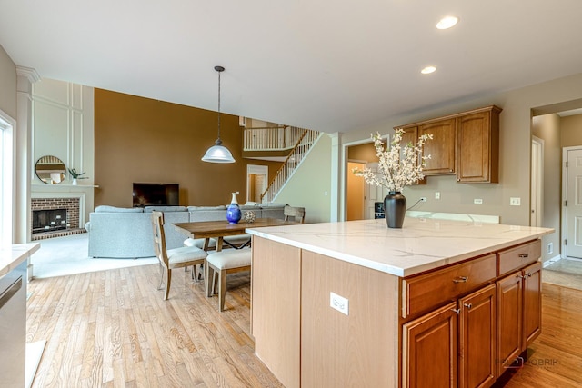 1430 Mcclellan Ct, Lindenhurst, IL 60046 - kitchen with light wood-type flooring, pendant lighting, light stone countertops, a fireplace, and open floor plan