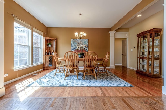 1430 Mcclellan Ct, Lindenhurst, IL 60046 - dining space featuring wood finished floors, a chandelier, baseboards, and decorative columns