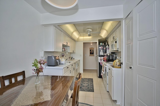 4901 Golf Rd Unit 310, Skokie, IL 60077 - kitchen with light tile patterned floors, light countertops, white appliances, a raised ceiling, and white cabinets