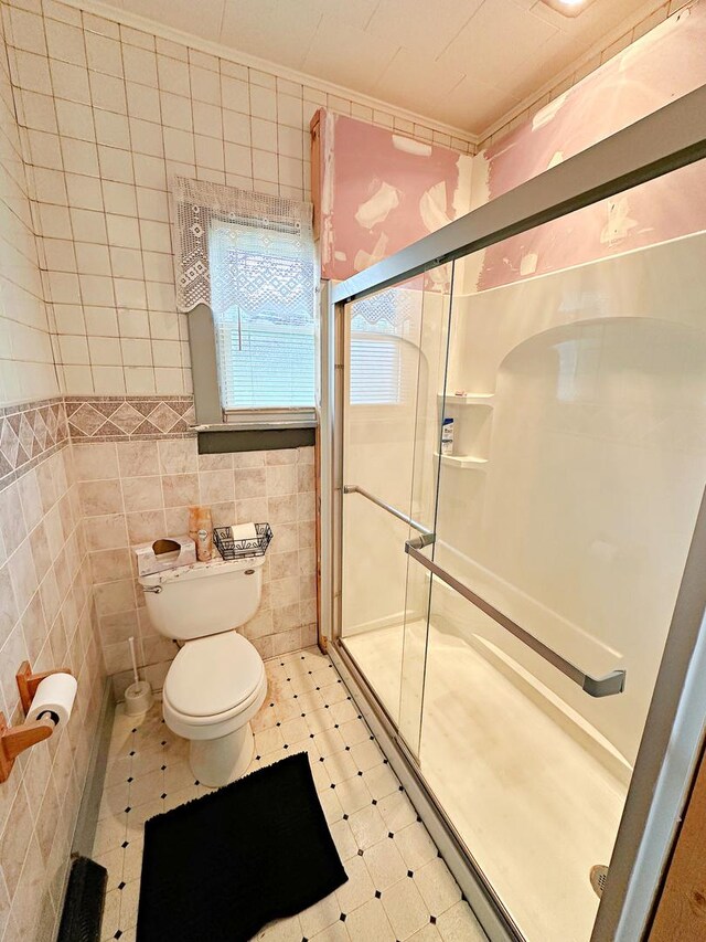 117 W 9th St, Streator, IL 61364 - full bathroom with tile walls, toilet, a shower stall, and tile patterned floors