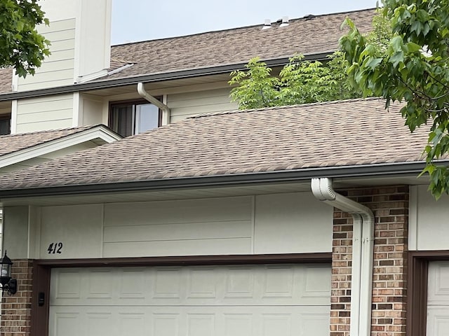 412 Bluebird Ln Unit 412, Deerfield, IL 60015 - exterior view of roof with shingles, a downspout, and gutters