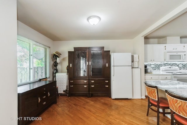412 Bluebird Ln Unit 412, Deerfield, IL 60015 - kitchen with white appliances, light wood-style flooring, white cabinets, and backsplash