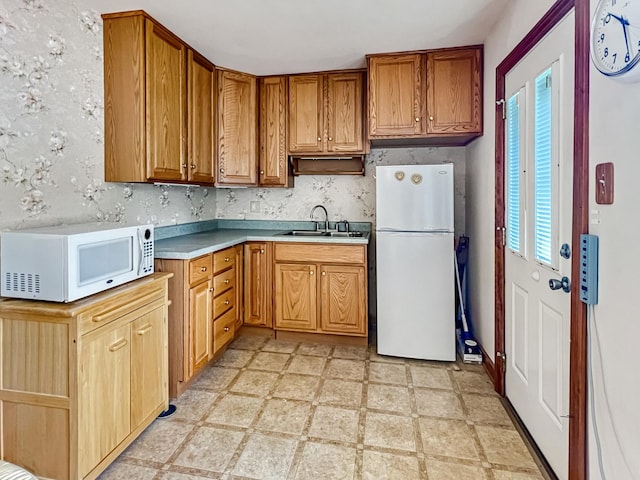 2519 Apache Ave, Sauk Village, IL 60411 - kitchen featuring white appliances, a sink, light countertops, light floors, and brown cabinetry