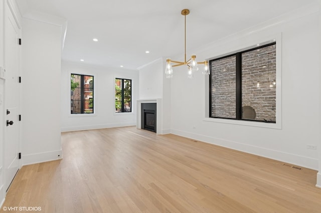2118 N Sheffield Ave Unit 1, Chicago, IL 60614 - unfurnished living room featuring light wood-style flooring, a glass covered fireplace, crown molding, and recessed lighting