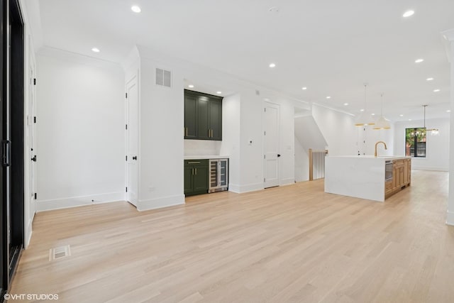 2118 N Sheffield Ave Unit 1, Chicago, IL 60614 - unfurnished living room with wine cooler, light wood-style flooring, recessed lighting, bar, and ornamental molding