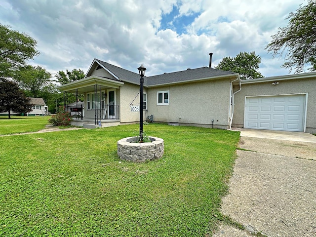 1003 Bazore St, Streator, IL 61364 - view of front of property with concrete driveway, a porch, a front lawn, and stucco siding