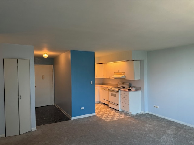 20 N Tower Rd Unit 6J, Oak Brook, IL 60523 - kitchen with white gas range, under cabinet range hood, baseboards, and white cabinetry