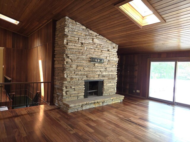 1720 Stratford Ln, Rockford, IL 61107 - unfurnished living room featuring a skylight, lofted ceiling, wooden ceiling, wood walls, and a fireplace