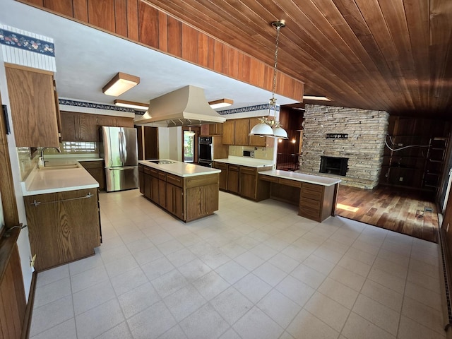1720 Stratford Ln, Rockford, IL 61107 - kitchen featuring freestanding refrigerator, island range hood, a sink, light countertops, and a fireplace
