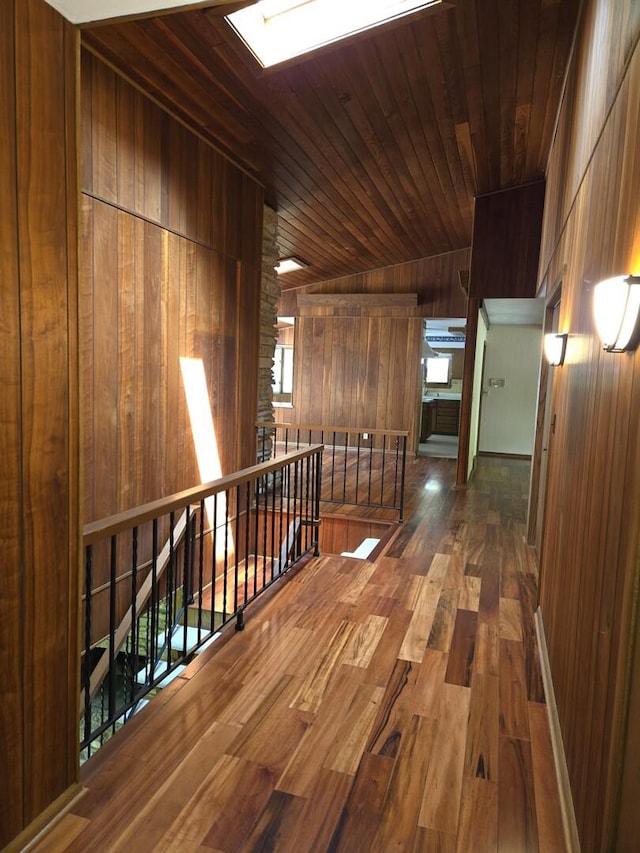 1720 Stratford Ln, Rockford, IL 61107 - hallway with an upstairs landing, wood walls, wood finished floors, wooden ceiling, and a skylight