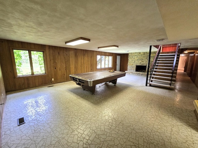 1720 Stratford Ln, Rockford, IL 61107 - recreation room with plenty of natural light, wood walls, a textured ceiling, a fireplace, and billiards table