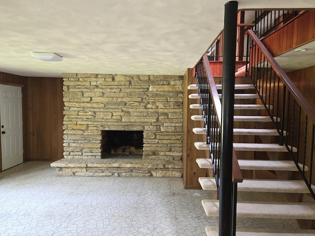 1720 Stratford Ln, Rockford, IL 61107 - staircase featuring a stone fireplace and wooden walls