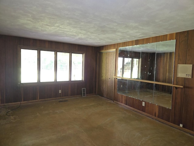 1720 Stratford Ln, Rockford, IL 61107 - spare room featuring plenty of natural light, wooden walls, and a textured ceiling
