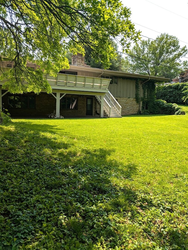 1720 Stratford Ln, Rockford, IL 61107 - rear view of property with stairs, board and batten siding, a chimney, a yard, and a wooden deck