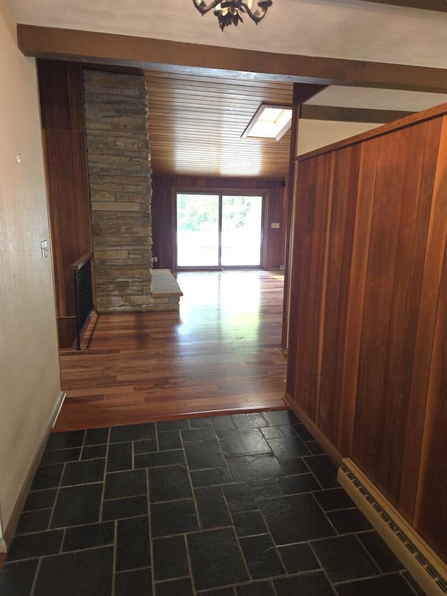 1720 Stratford Ln, Rockford, IL 61107 - corridor featuring a baseboard heating unit, wood walls, and baseboards