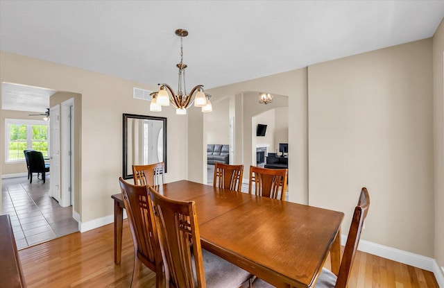 402 Cypress Ct, Saint Joseph, IL 61873 - dining area with a chandelier, baseboards, and light wood-style floors