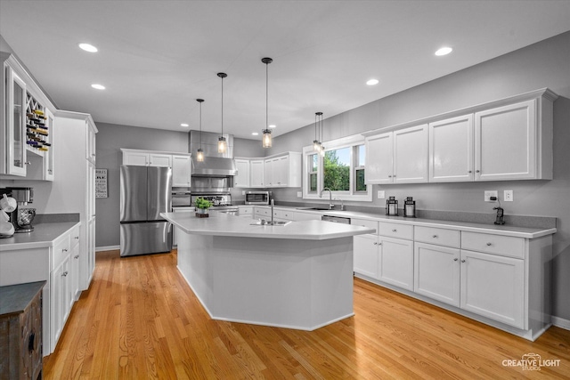 13214 Sunderlin Rd, Plainfield, IL 60585 - kitchen with appliances with stainless steel finishes, wall chimney exhaust hood, white cabinets, a sink, and an island with sink