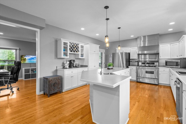 13214 Sunderlin Rd, Plainfield, IL 60585 - kitchen with wall chimney range hood, appliances with stainless steel finishes, a sink, recessed lighting, and a kitchen island