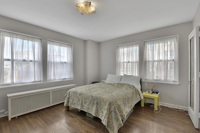 5555 N Sheridan Rd Unit 507, Chicago, IL 60640 - bedroom with radiator heating unit, multiple windows, dark wood-type flooring, and baseboards