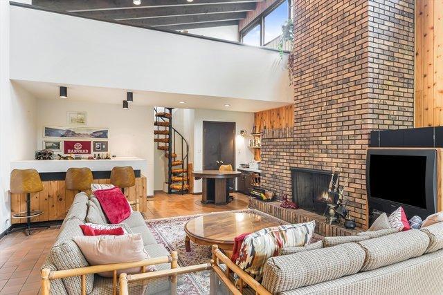 1314 S Chester Ave, Park Ridge, IL 60068 - living area featuring a towering ceiling, stairway, and a brick fireplace