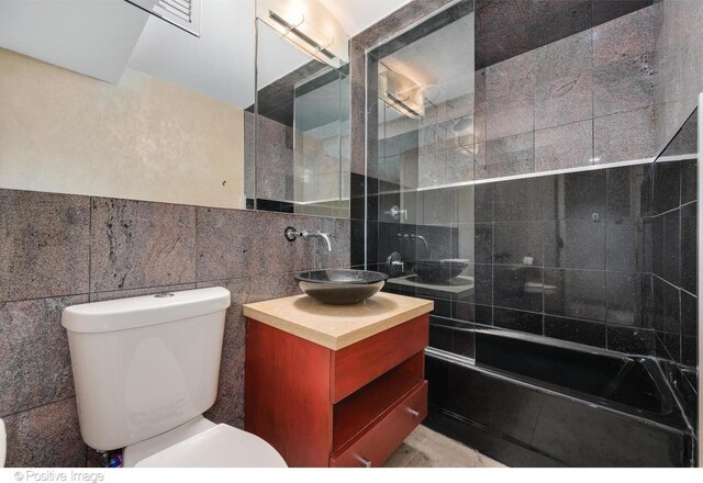 1 E Schiller St Unit 8B, Chicago, IL 60610 - bathroom featuring tile walls, toilet, vanity, and tiled shower / bath
