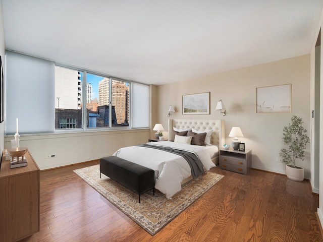 1 E Schiller St Unit 8B, Chicago, IL 60610 - bedroom featuring wood finished floors, baseboards, and a city view