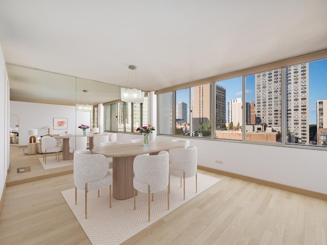 1 E Schiller St Unit 8B, Chicago, IL 60610 - dining area featuring a city view, light wood-style flooring, and baseboards