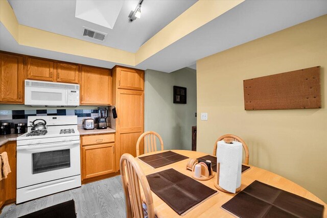 6719 W White Tailed Ln Unit 3E, Tinley Park, IL 60477 - kitchen with white appliances, light wood-style flooring, light countertops, and brown cabinetry