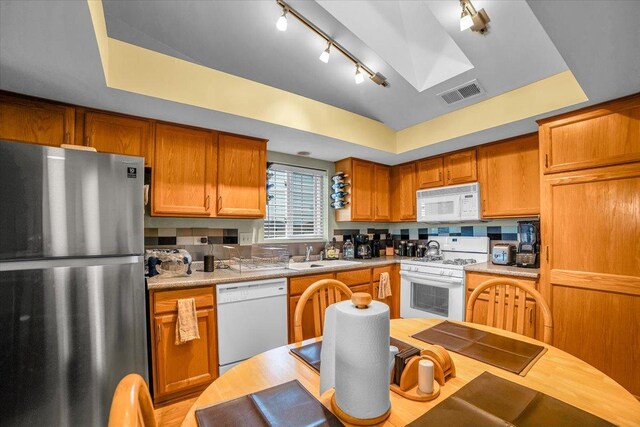 6719 W White Tailed Ln Unit 3E, Tinley Park, IL 60477 - kitchen featuring white appliances, a raised ceiling, a sink, track lighting, and light countertops