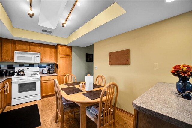 6719 W White Tailed Ln Unit 3E, Tinley Park, IL 60477 - kitchen featuring white appliances, light wood-style floors, track lighting, baseboards, and brown cabinets