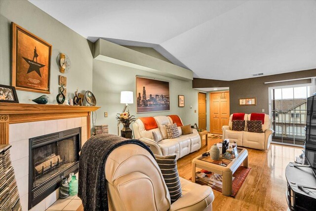 6719 W White Tailed Ln Unit 3E, Tinley Park, IL 60477 - living area featuring a tile fireplace, wood finished floors, and lofted ceiling