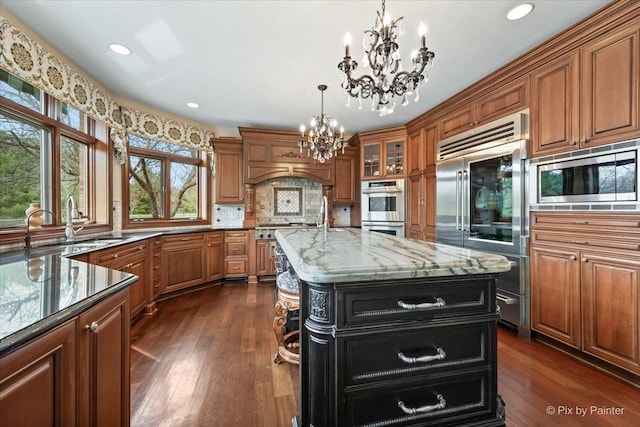 11 Moate Ln, Barrington Hills, IL 60010 - kitchen featuring a chandelier, built in appliances, brown cabinets, light stone countertops, and recessed lighting