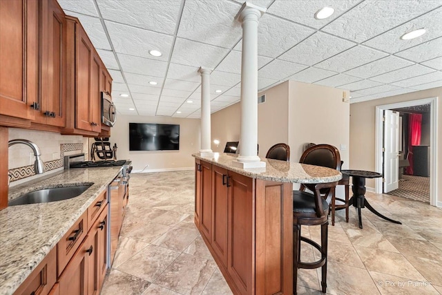 11 Moate Ln, Barrington Hills, IL 60010 - kitchen with a sink, baseboards, stainless steel appliances, brown cabinetry, and a breakfast bar