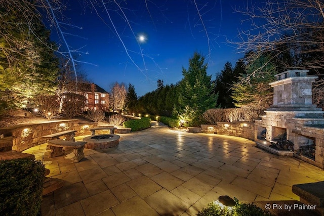 11 Moate Ln, Barrington Hills, IL 60010 - patio at twilight with an outdoor stone fireplace, a patio, and an outdoor fire pit