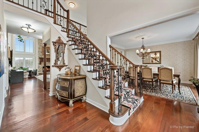 11 Moate Ln, Barrington Hills, IL 60010 - stairs featuring wood finished floors, a chandelier, baseboards, a towering ceiling, and wallpapered walls