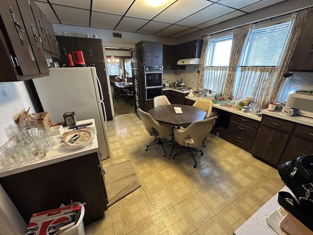 347 156th St, Calumet City, IL 60409 - kitchen featuring white appliances, light countertops, dark brown cabinets, and a drop ceiling