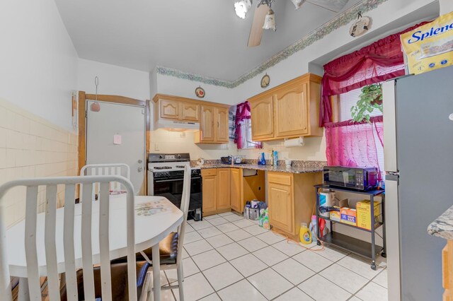 1721 N Menard Ave, Chicago, IL 60639 - kitchen featuring white range with gas stovetop, freestanding refrigerator, under cabinet range hood, light tile patterned flooring, and light brown cabinets