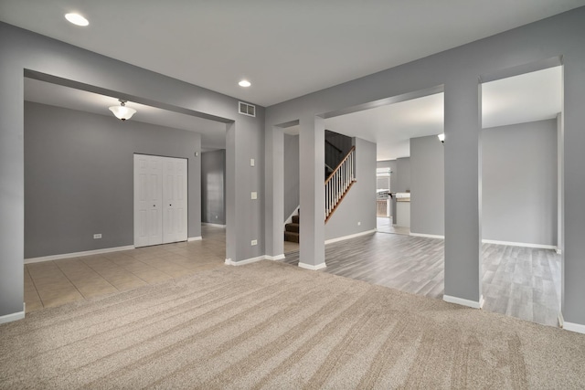 8013 Shady Oak Rd, Joliet, IL 60431 - unfurnished living room with carpet, stairs, baseboards, recessed lighting, and tile patterned floors